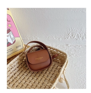 Detail of vintage brown leather mini crossbody bag for girls with gold letter embossing