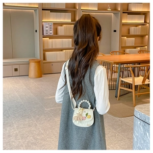 Détail du mini sac blanc pour fille avec poignée en perles et décor de lapin en peluche