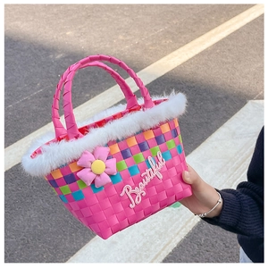 Detail of colorful woven basket bag with white faux fur trim and pink floral accent