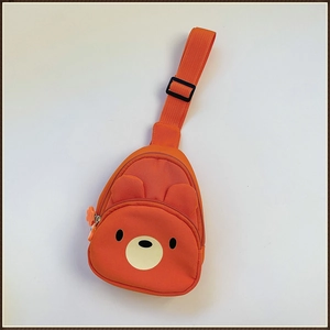 Détail du sac de poitrine orange ours en toile avec sangle réglable et pendentif fleur