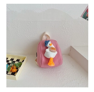 Detail of pink canvas mini backpack featuring a 3D plush duck with a blue hat and bag
