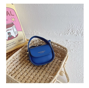 Close-up of blue mini leather handbag for girls inside a stylish woven basket detail
