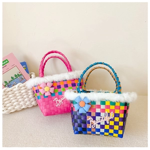 Detail of hand-woven colorful plaid kids handbag with faux fur trim and flower charm