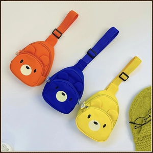 Détail des sacs de poitrine pour enfants avec ours en orange, bleu et jaune