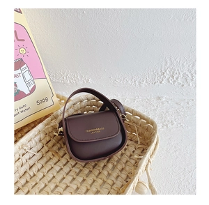 Detail view of mini vintage handbag for girls with gold hardware in a woven basket