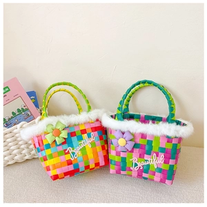 Detail view of woven colorful bucket bag for kids with white faux fur and floral accents