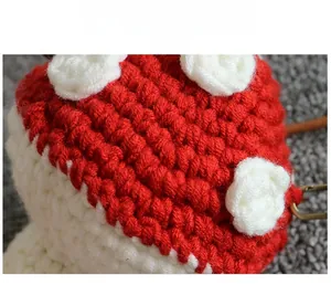 Macro detail of hand-knitted mushroom bag showing red yarn texture and white polka dots