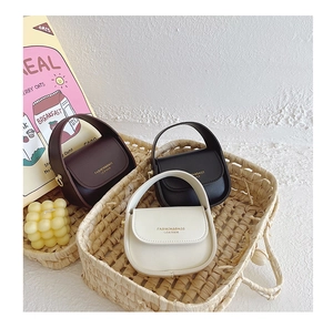 Detailed view of mini leather handbags in brown, black, and white for young girls