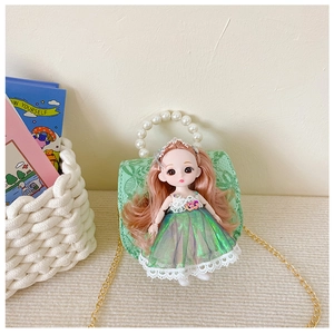 Detailed view of green floral lace kids handbag featuring a 3D doll and pearl handle