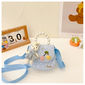 Détail du sac à main en dentelle bleu clair pour enfants avec perles et poupée lapin