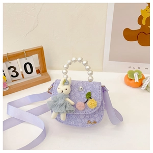 Détail de petit sac violet pour fille avec poignée en perles et poupée lapin