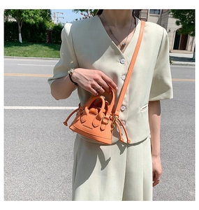 Orange mini shell bag featuring side drawstring detail and removable shoulder strap