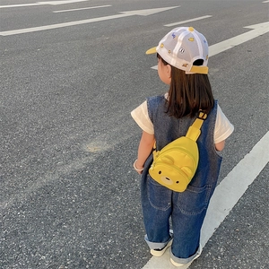 Sac bandoulière enfant jaune motif ours mignon porté par un enfant à l'extérieur