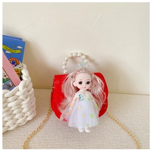 Detail of red princess mini handbag with pearl handle and cute doll decoration