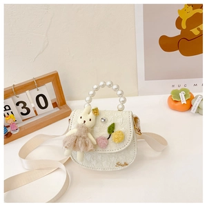 Détail du sac à bandoulière lapin crème avec poignée en perles et texture de dentelle