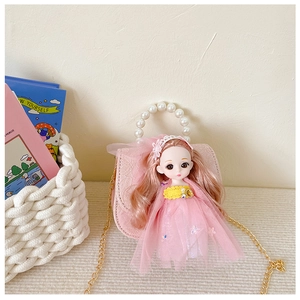 Detail of pink girls mini handbag with lace texture, doll ornament and pearl handle