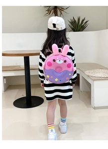 Fillette portant un sac à dos coque rigide en forme de donut rose avec oreilles de lapin