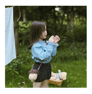 Handmade woven acorn crossbody bag for toddlers featuring natural brown and cream colors