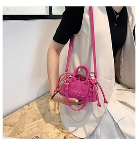 Detail of pink mini shell bag for kids with handles and detachable crossbody strap