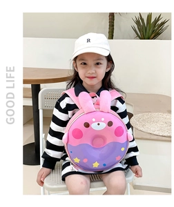 Fillette portant un sac à dos donut rose et violet avec détails d'oreilles en peluche