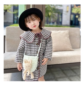 Détail du sac lapin tricoté blanc assorti à un manteau en pied-de-poule pour petits enfants