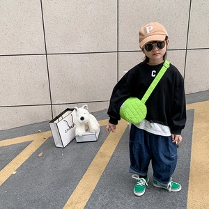 Child bright green quilted crossbody bag paired with street style outfit and sneakers
