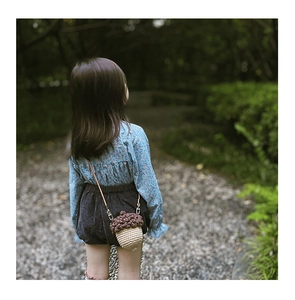 Detailed view of handmade crochet acorn crossbody bag for kids in outdoor park setting