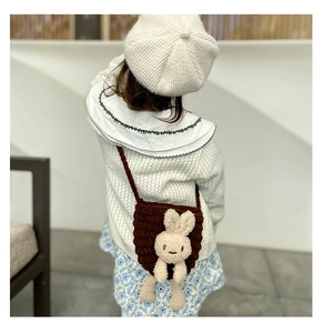 Détail d'un sac à bandoulière tricoté marron pour filles avec décor de lapin en peluche