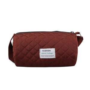 Red-brown quilted cylinder crossbody bag for kids featuring a minimalist canvas design