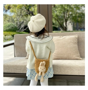 Détail d'un sac à bandoulière tricoté pour enfant avec lapin en peluche 3D et sangle