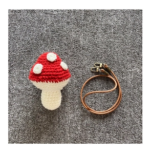 Macro shot of hand-knitted red mushroom bag with white dots and metal buckle strap