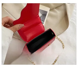 Detail view showing internal single compartment of red mini chain bag with gold strap