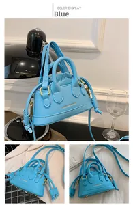 Close-up of light blue mini shell bag with drawstring lining and gold hardware accents