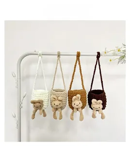Détail de quatre sacs en bandoulière tricotés pour enfants avec des motifs de lapin