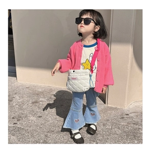 Détail d'un petit sac bandoulière matelassé et jean enfant avec patchs cœurs brodés