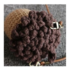 Detail of handmade crochet mushroom bag with textured ball stitch and leather strap