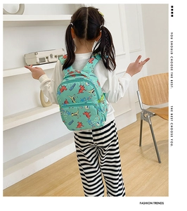 Toddler backpack featuring colorful cartoon dinosaur prints with front zipper pocket detail