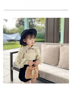 Girl's winter look featuring a brown chunky knit handbag and cream ruffle sweater