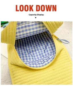 Macro view of kids backpack showing yellow quilted fabric and blue checkered lining capacity