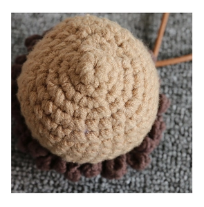 Macro shot of handmade crochet acorn bag showing detailed brown knit texture and pattern