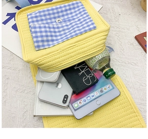Internal view of yellow quilted backpack showing storage capacity for tablets and cosmetics