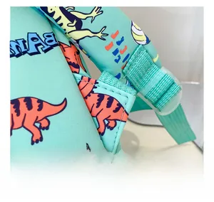Detail showing reinforced stitching and adjustable plastic buckle on kids dinosaur backpack