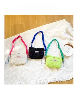 Détail de sacs bandoulière en nylon matelassé avec des bretelles à volants en blanc et noir
