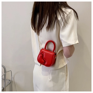 Detailed view of the mini red leather crossbody bag with chain strap and top handle