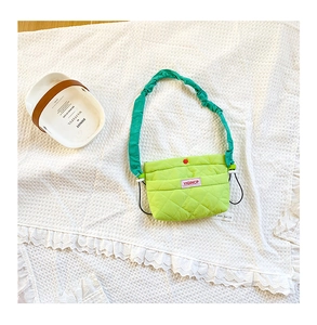 Gros plan sur le sac bandoulière enfant en nylon matelassé vert fluo avec bandoulière plissée