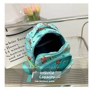 Detail view showing internal compartment and green dinosaur pattern of children backpack