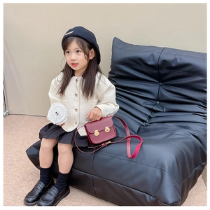 Détail d'un sac à bandoulière carré vintage en cuir PU bordeaux sur enfant
