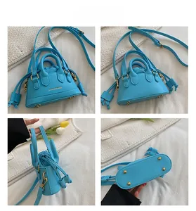 Detail view of sky blue shell bag with gold studs, drawstring closure and logo