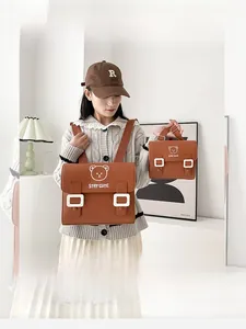 Detail view of brown PU leather backpacks featuring cute bear prints and white buckles