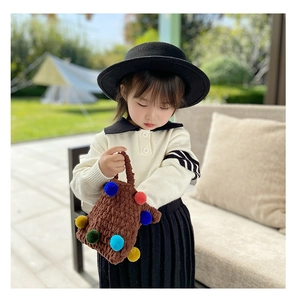 Detailed view of winter plush knitted handbag with colorful pom-poms for girls